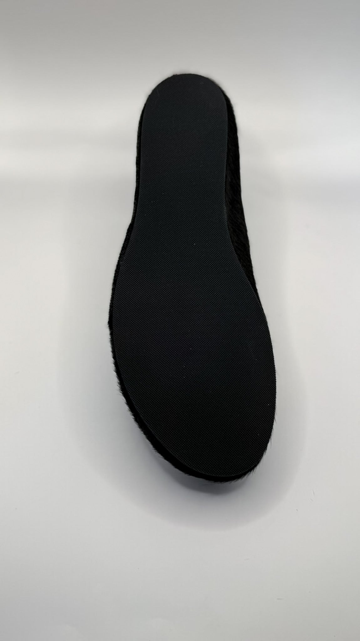 Black shoe sole on a light gray background